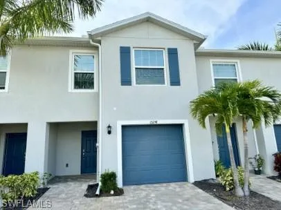 Two-story stucco exterior featuring a blue garage door and matching entry door