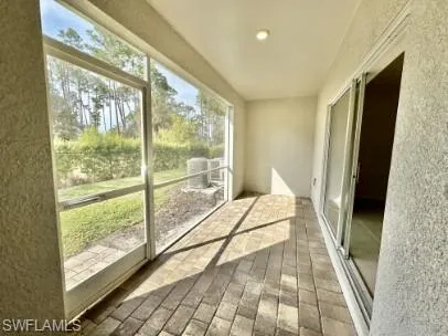 Screened lanai featuring paver flooring, recessed lighting, and direct access to interior spaces through a sliding glass door