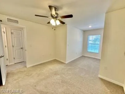 Carpeted room featuring a ceiling fan with integrated lighting, a window with horizontal blinds, and a recessed light fixture