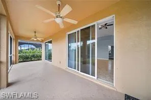Covered patio with multiple ceiling fans, screened enclosure, and large sliding glass doors