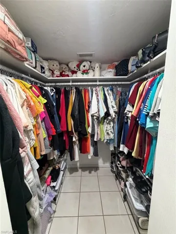 Walk in closet with light tile patterned floors