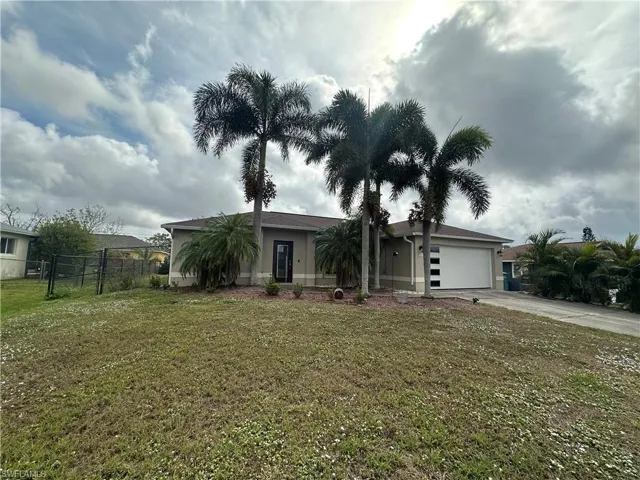 Ranch-style house with a front yard and a garage