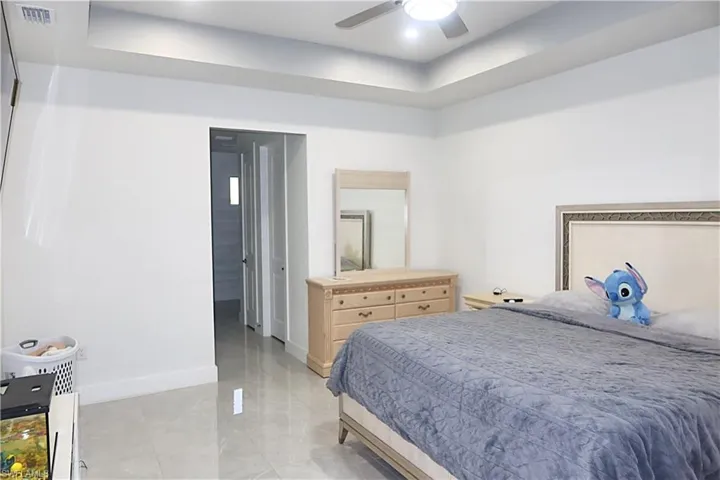 Bedroom featuring a raised ceiling and a ceiling fan