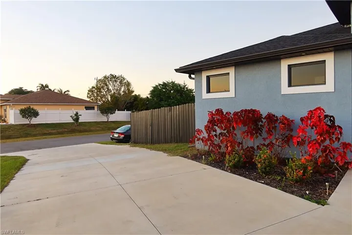 View of home's exterior featuring stucco siding, roof with shingles, and concrete driveway