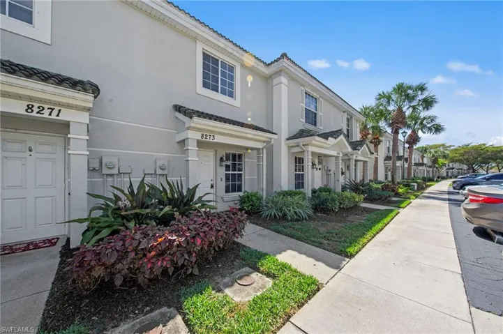 View of front of home featuring stucco siding, a tiled roof, and a residential view