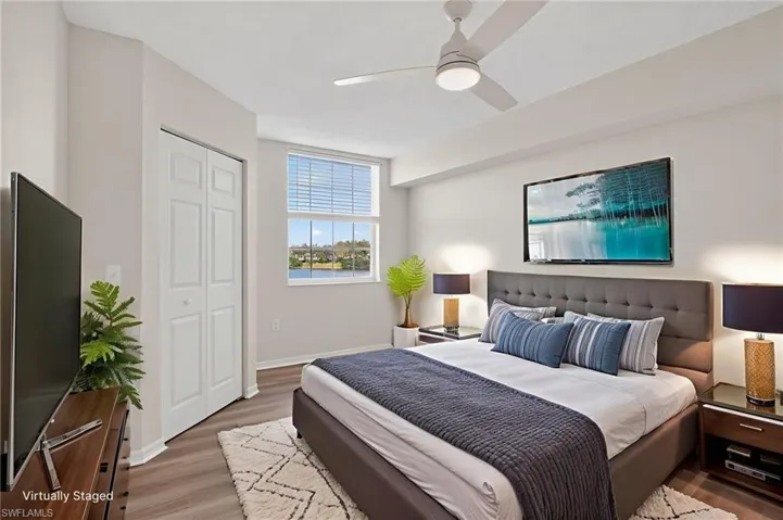 Bedroom with wood finished floors, walk in closet, and ceiling fan