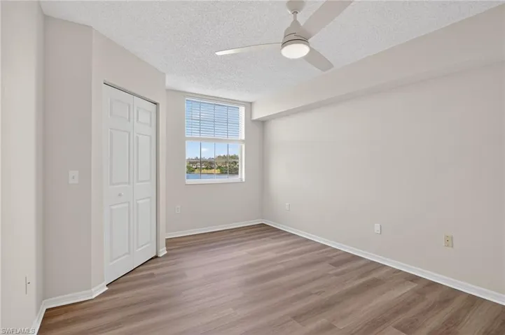 Unfurnished bedroom with a ceiling fan and walk in closet