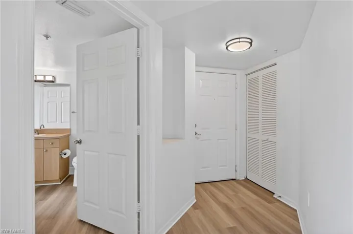 Hallway with light wood finished floors and baseboards
