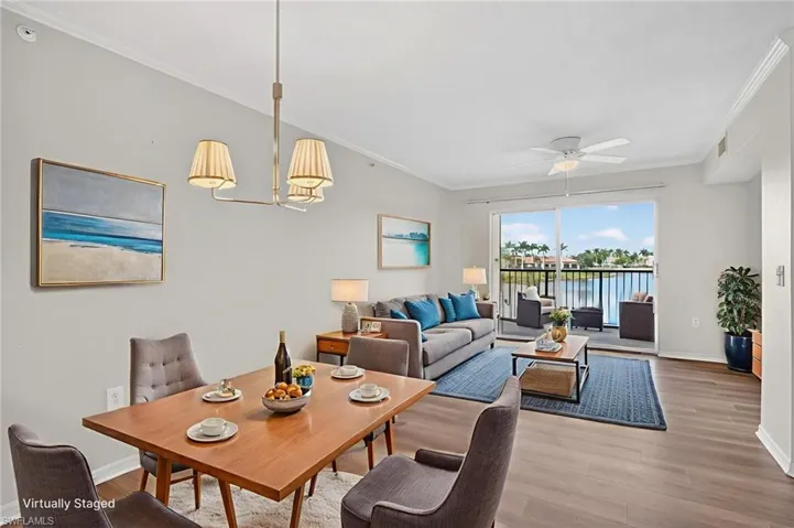 Great room and Dining space with light wood-type flooring, ornamental molding, a ceiling fan and a water view