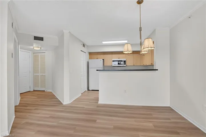 Kitchen featuring refrigerator, lighting, ornamental molding, countertops, and all new light LVP flooring