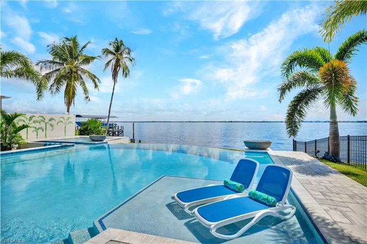 View of pool featuring an infinity pool, a water view, and a patio
