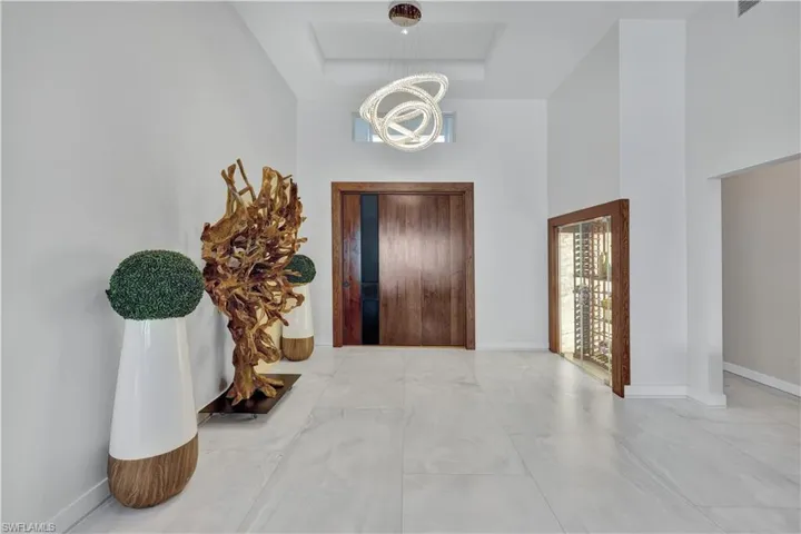Foyer with a high ceiling, a chandelier, and a raised ceiling