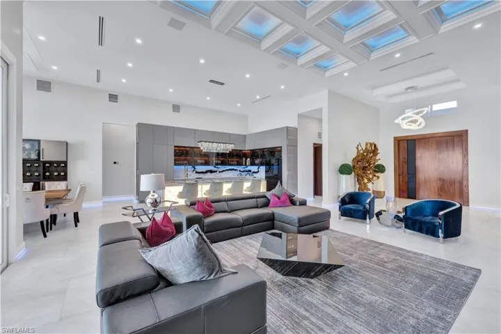 Living area with a towering ceiling, coffered ceiling, and recessed lighting