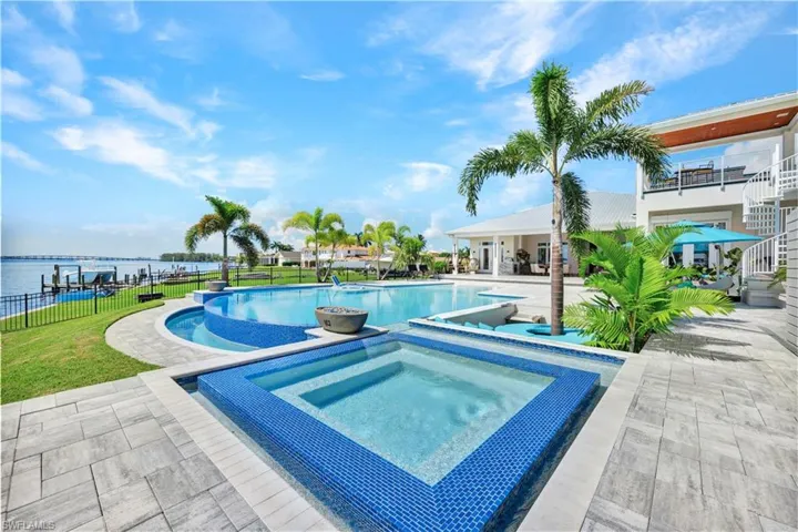 View of pool with a patio area and an in-ground hot tub