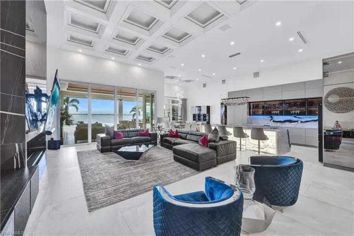 Lobby with coffered ceiling, a towering ceiling, recessed lighting, and beam ceiling