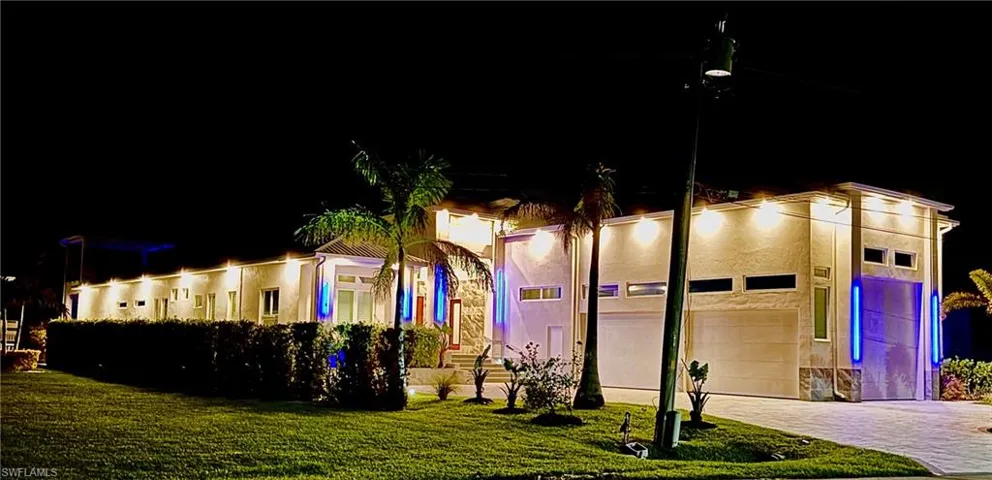 View of front of home featuring a garage, a yard, decorative driveway, and stucco siding