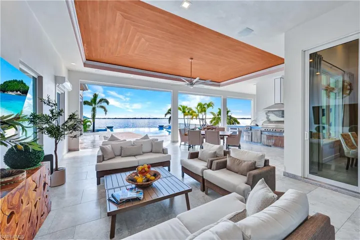 View of patio / terrace featuring ceiling fan, outdoor dining space, a water view, an outdoor kitchen, and an outdoor hangout area