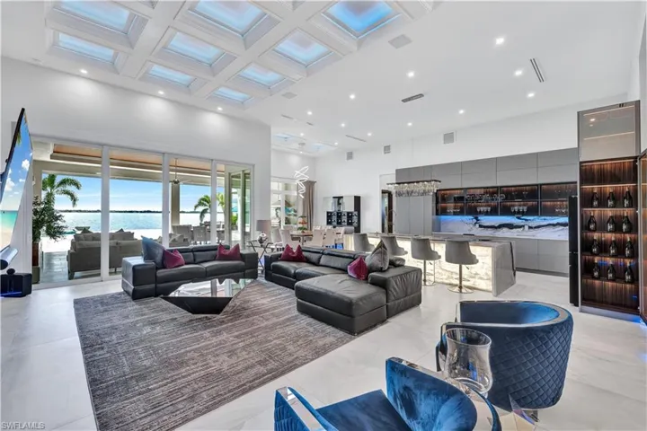 Living room featuring coffered ceiling, a towering ceiling, and recessed lighting