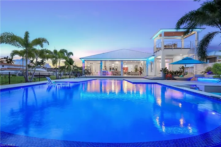 Pool at dusk featuring a patio area, a hot tub, and a sundowner deck (sunrise and sunset)