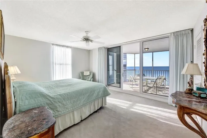 Carpeted bedroom featuring a water view, ceiling fan, a textured ceiling, and access to outside