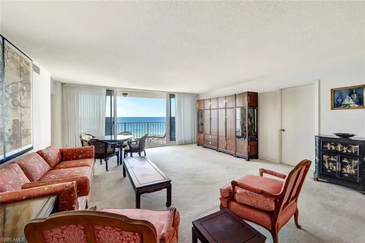 Carpeted living room featuring a water view and a textured ceiling