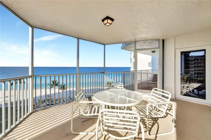 Sunroom with a beach view and a water view