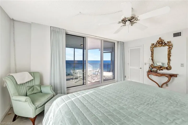 Bedroom with a water view, ceiling fan, a textured ceiling, and access to outside