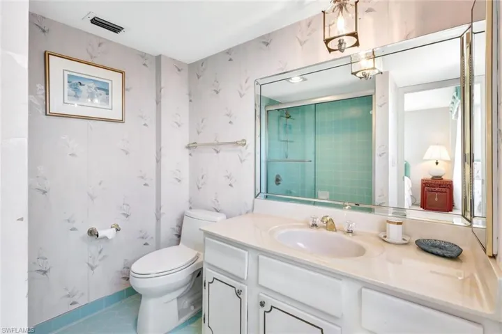 Bathroom featuring vanity, tile patterned floors, toilet, and walk in shower