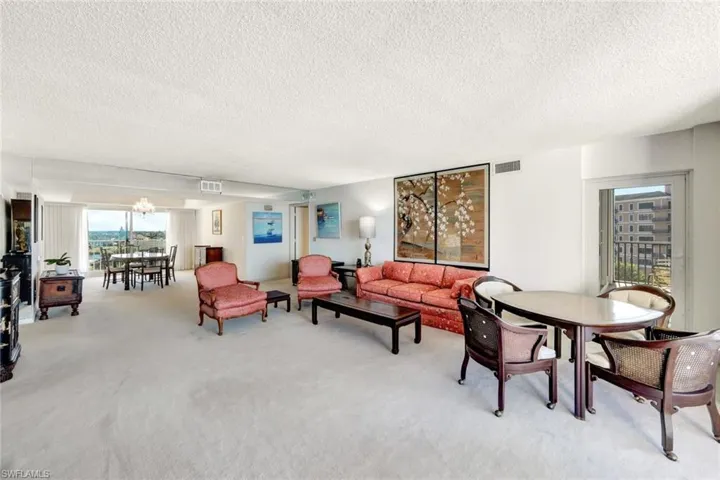 Carpeted living room with a textured ceiling and a chandelier