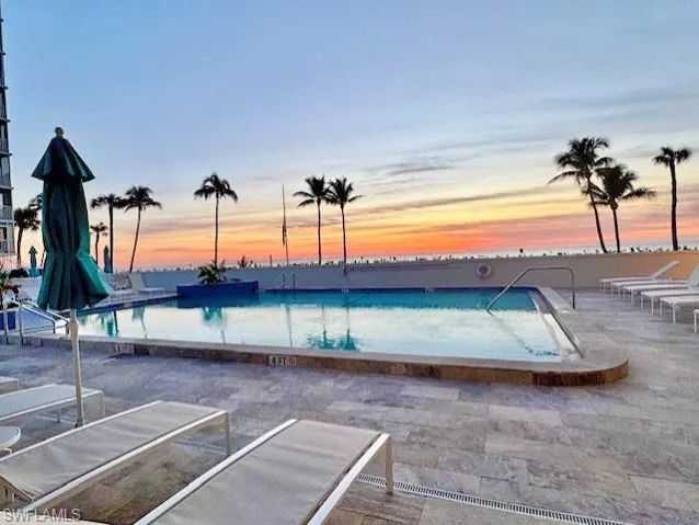 Pool at dusk with a patio area