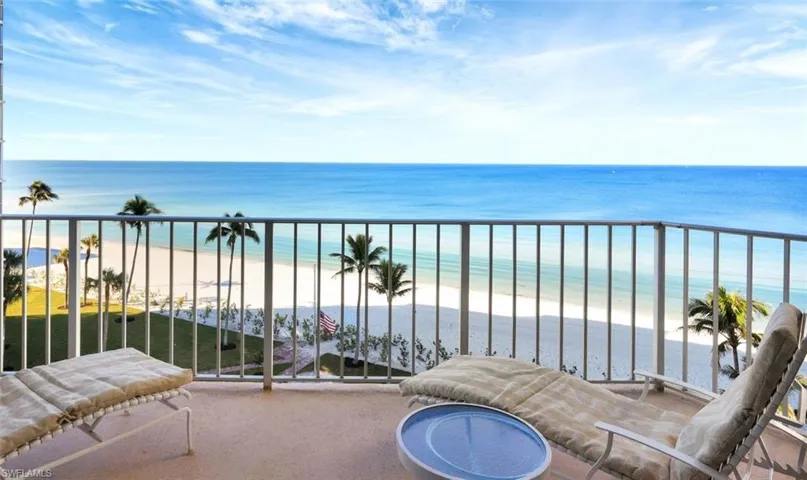 Balcony featuring a water view and a beach view