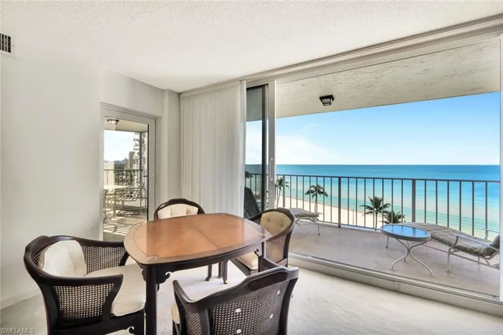 Dining space featuring a water view, a beach view, and a textured ceiling