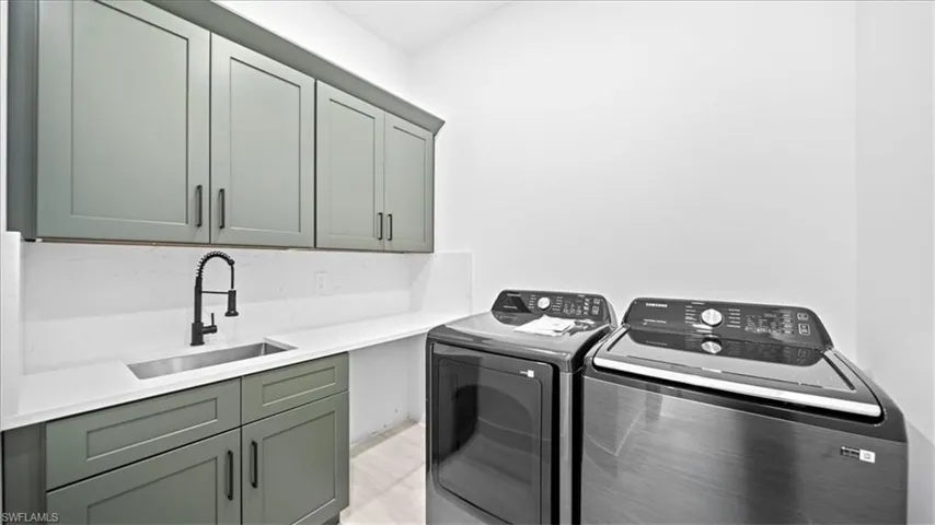 Laundry area featuring washer and clothes dryer and cabinet space