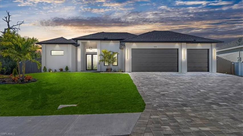 Prairie-style house featuring a garage, decorative driveway, and stucco siding