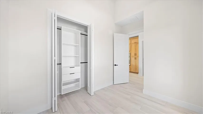 Unfurnished bedroom with light wood-style floors and a closet