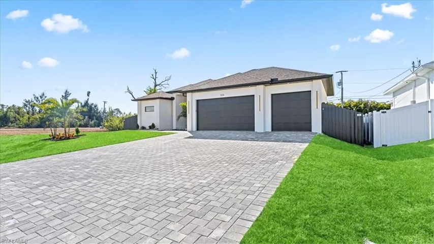 View of front of home featuring decorative driveway, a garage, and stucco siding
