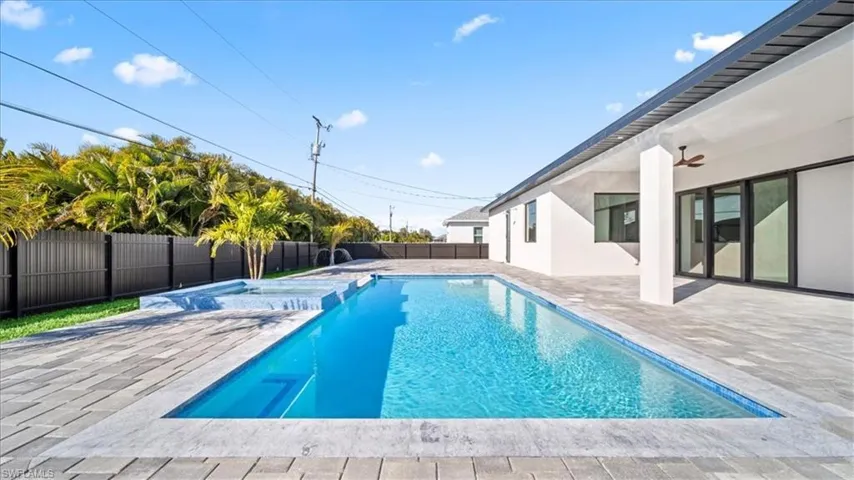Integrated pool / spa with a patio and a fenced backyard