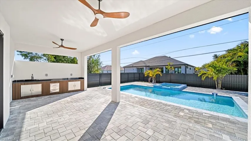 Relaxing pool / spa featuring a patio area, a fenced backyard, and area for grilling