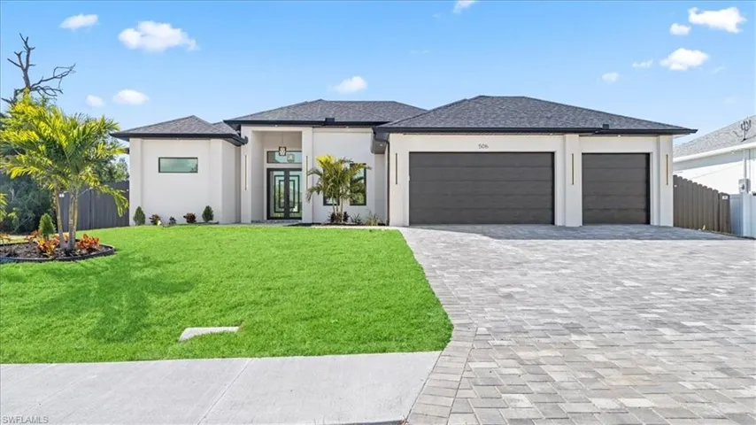 Prairie-style home with an attached garage, decorative driveway, and stucco siding