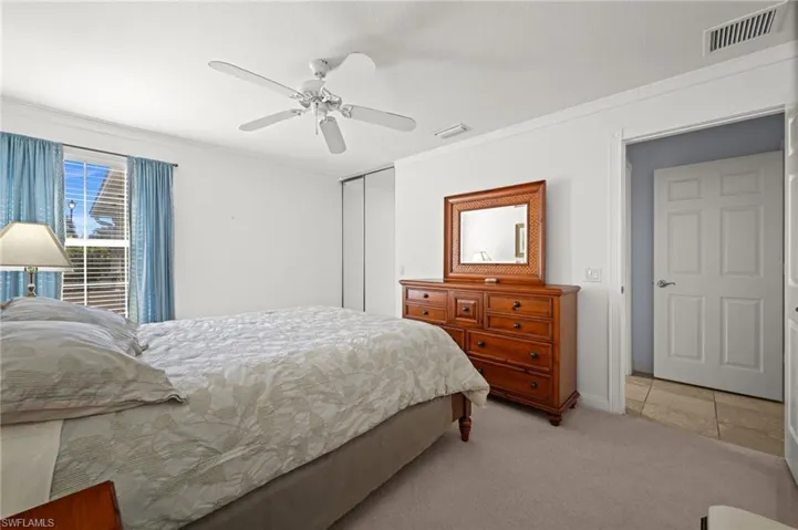 Bedroom featuring light colored carpet, a closet, ceiling fan, and crown molding