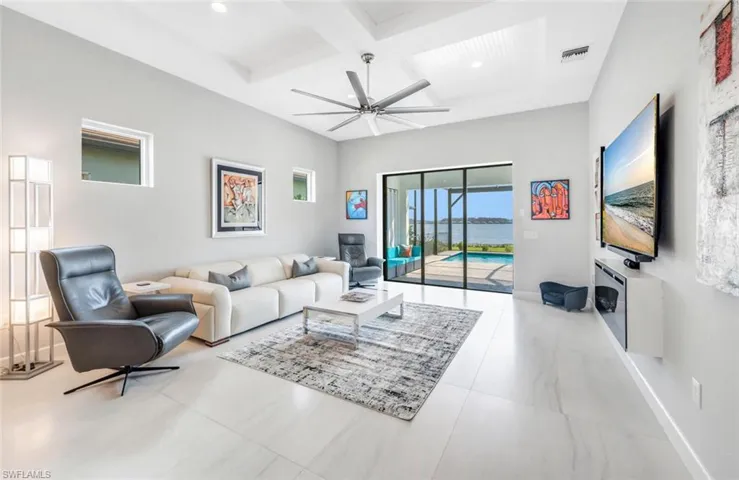 Living room with beamed ceiling, coffered ceiling, and ceiling fan
