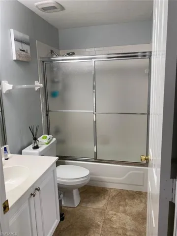 Bathroom with vanity and enclosed tub / shower combo