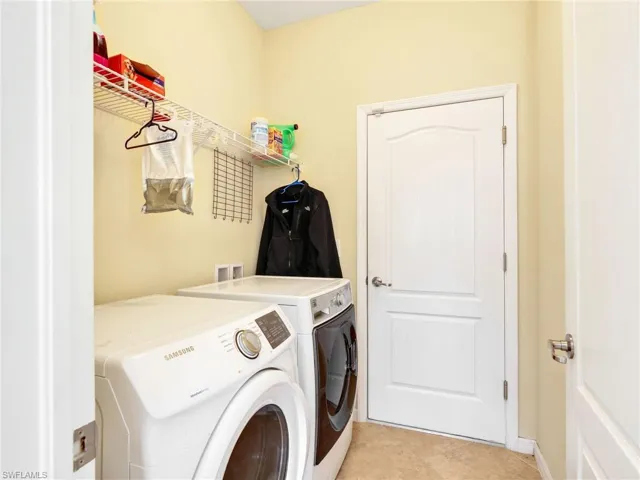 Washroom featuring separate washer and dryer and light tile patterned floors