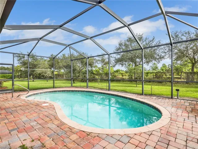 Outdoor pool featuring a lawn, glass enclosure, and a sunroom