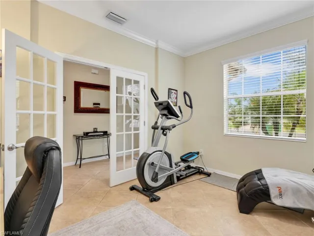 Offiece/Exercise area with french doors, crown molding, and light tile patterned flooring