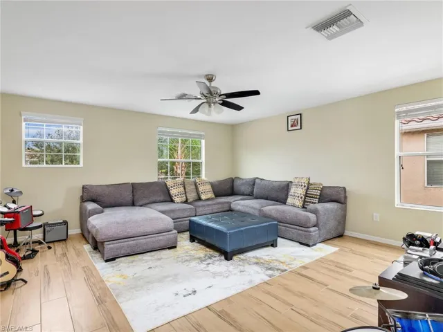 Living room/Loft with wood finished tile floors and ceiling fan