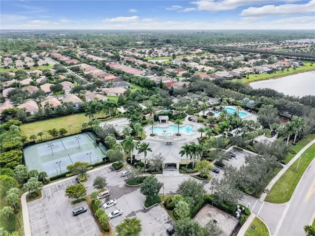 Aerial view of residential area with a pool and a nearby body of water