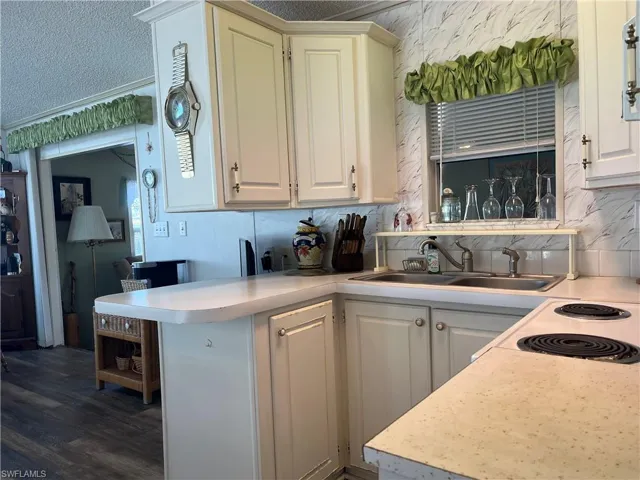 Kitchen featuring light countertops, a textured ceiling, and dark wood-style floors