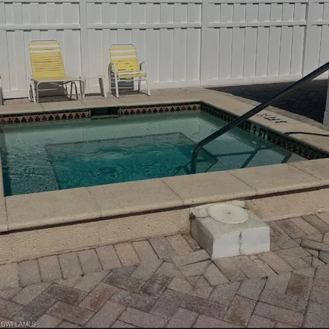 View of swimming pool with an in-ground hot tub and a swimming pool