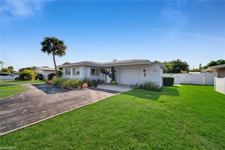 Single-story residence featuring a white stucco exterior and a tiled roof